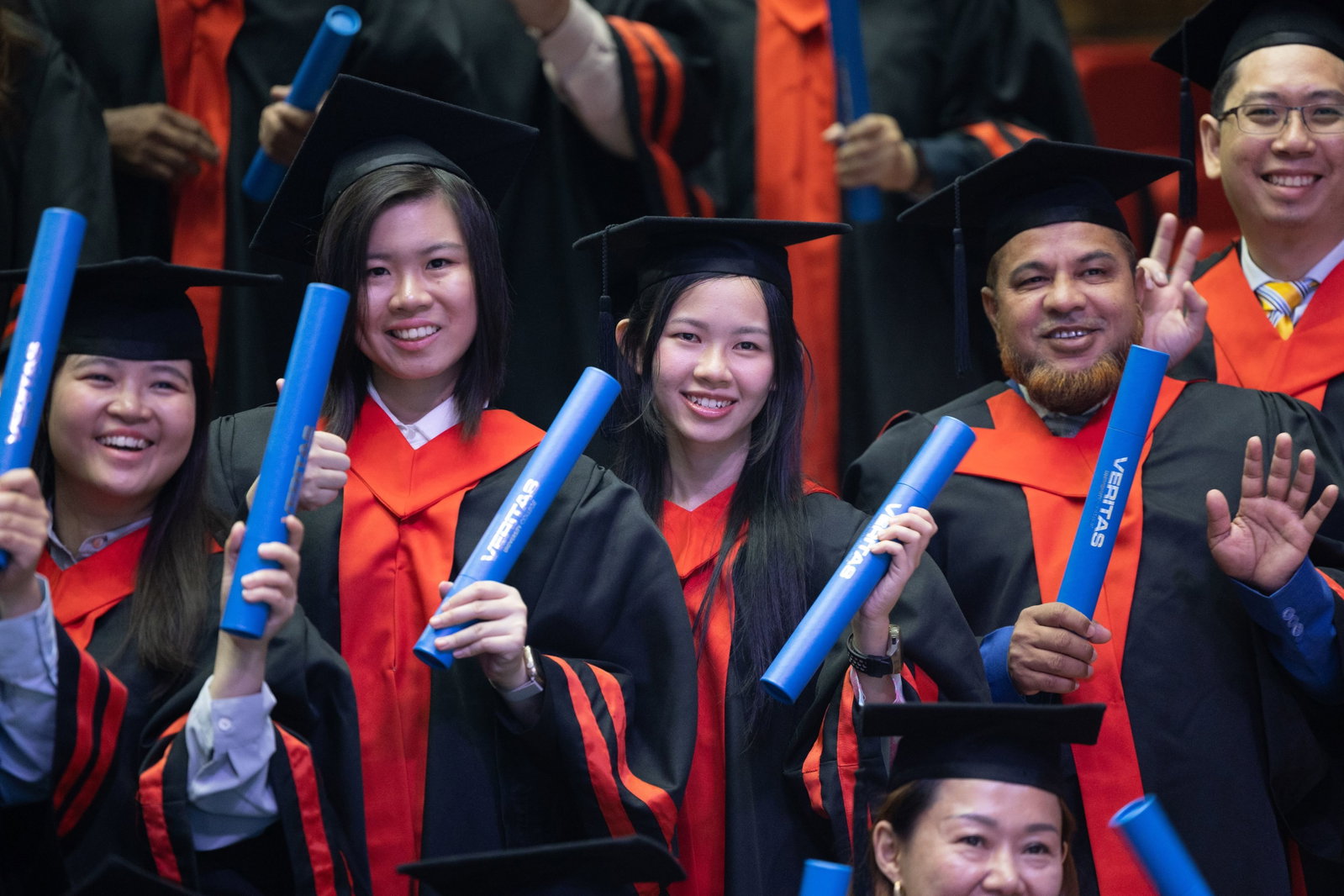smiling woman wearing academic dress and black academic hat