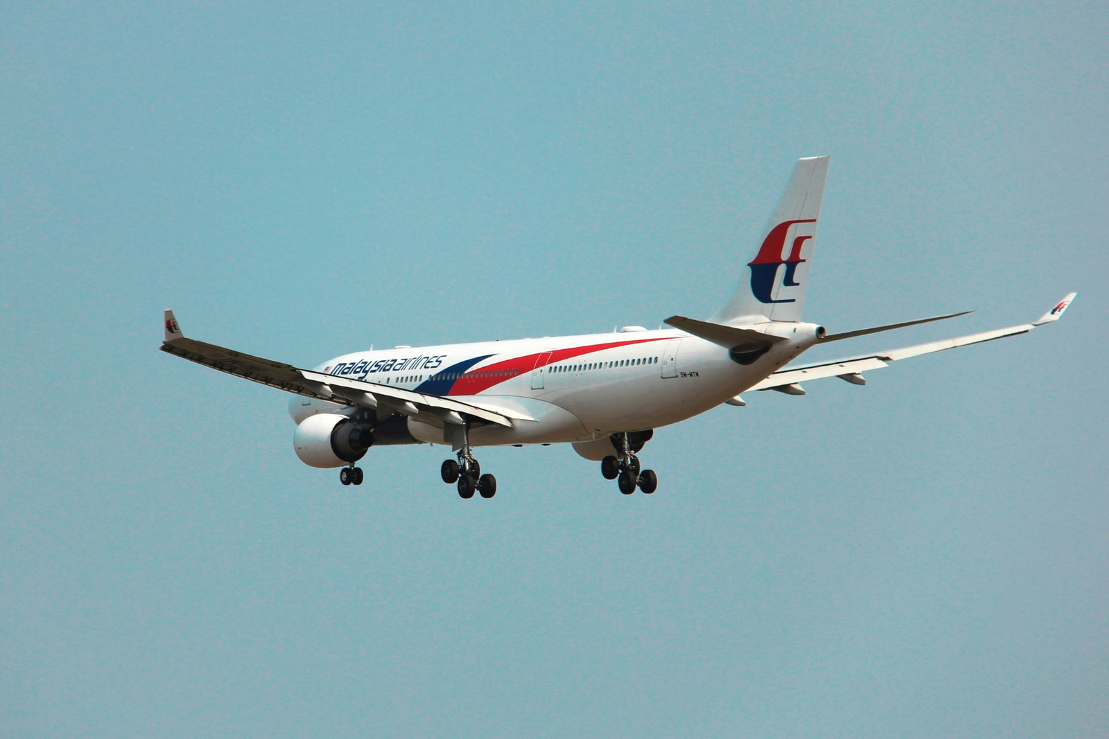 a large jetliner flying through a blue sky
